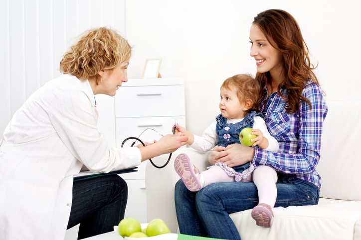 A compassionate pediatrician examines a child, while the child's mother offers comfort and support, fostering a positive healthcare experience for the entire family.