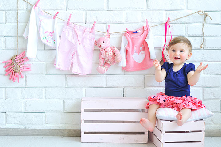 A curious toddler, exploring their surroundings, sitting next to a clothing rack