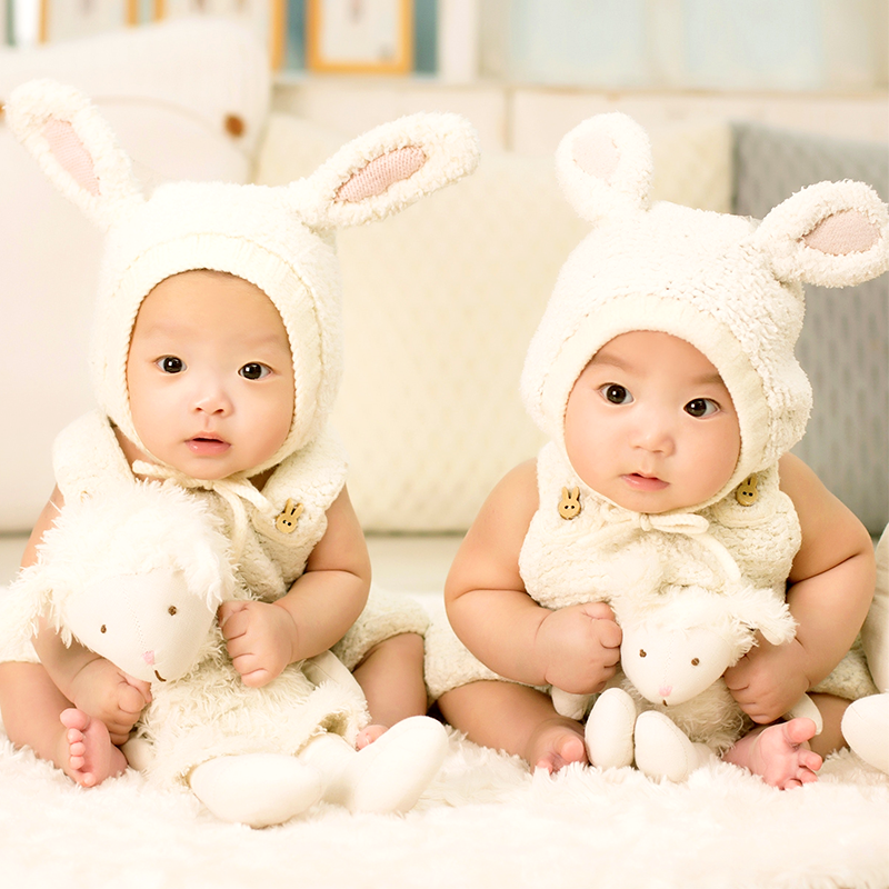 Two adorable twin babies, dressed in matching bunny costumes, a heartwarming image of sibling love and innocence.