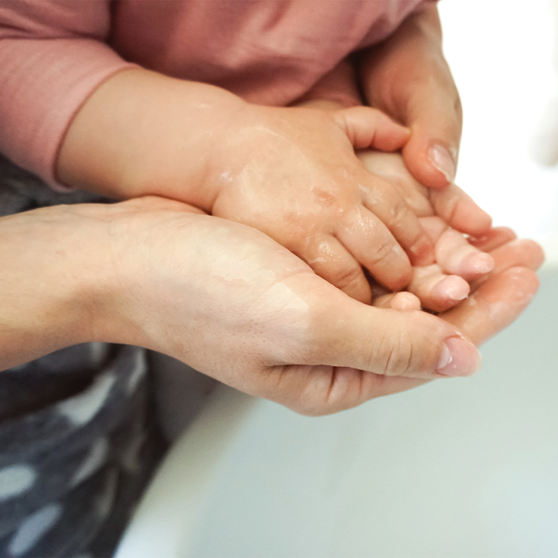 A caring mother and child wash their hands together, a simple yet effective way to prevent the spread of germs and maintain good hygiene.