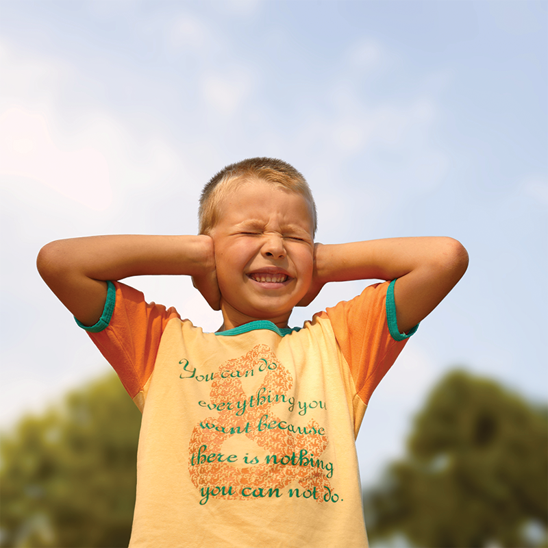 A frightened child covers their ears, seeking protection from the loud noise of fireworks.