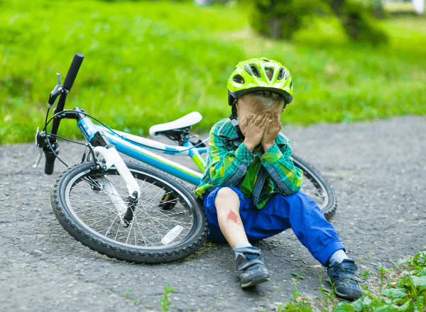 Boy crying next to bike on the ground