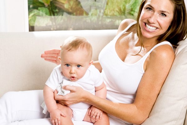 A caring mother gently pats her baby's back to help them burp, a common and essential post-feeding routine