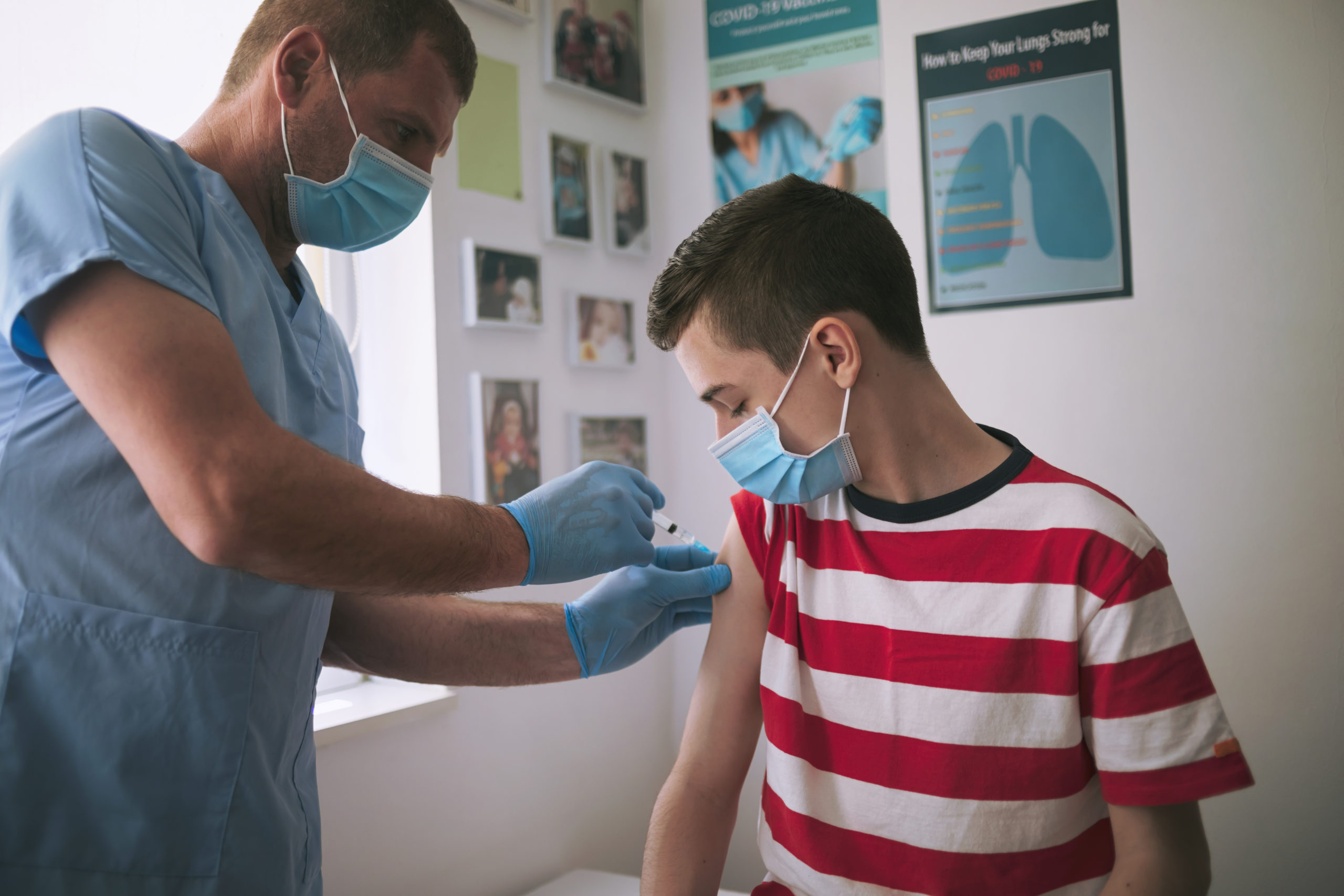 A dedicated healthcare professional administers a vaccine to a teenage boy, ensuring his protection against preventable diseases.