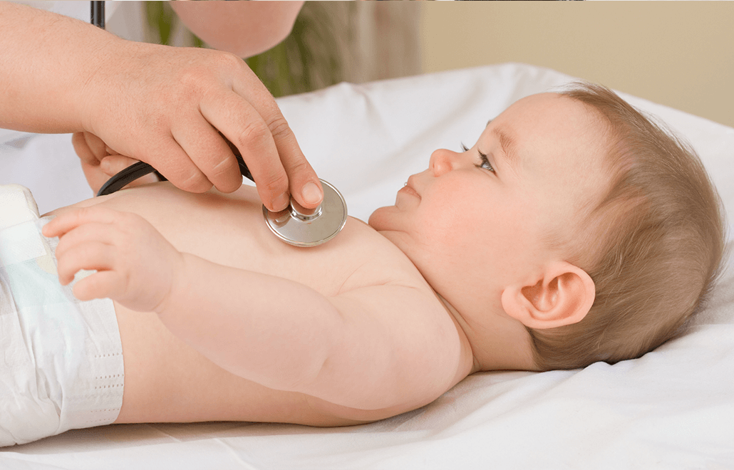 A pediatrician uses a stethoscope to listen to a child's heart and lungs during a routine well-child check-up.