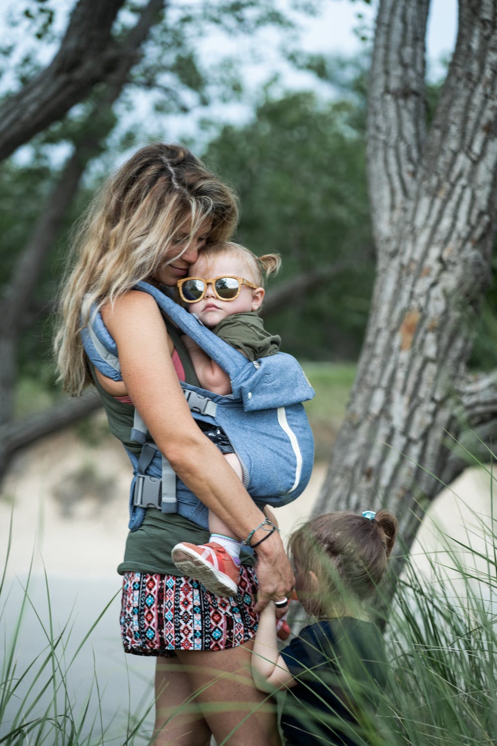 A loving mother carries her child, shielding them from the sun's rays to protect their delicate skin.