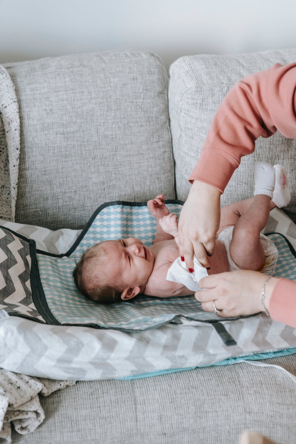 A caring mother gently changes her baby's diaper, ensuring their comfort and cleanliness.