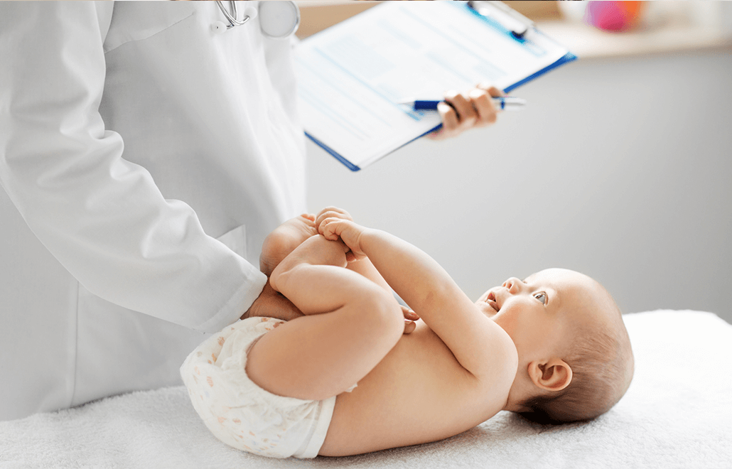 A pediatrician carefully examines a newborn baby during their first check-up.