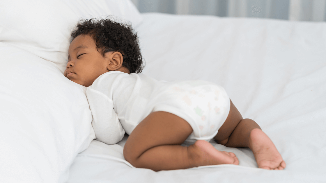 Sleeping baby lying on tummy to illustrate the importance of healthy sleep routines for children