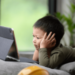 Child on tablet during holidays. Ideas promoting screen-free activities after the holidays.