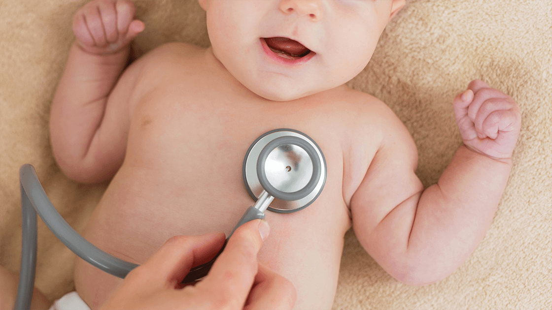 A pediatrician listing a child’s heart during a routine check-up.