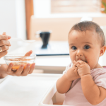 Child experiencing skin rash after eating, with concerned parent nearby