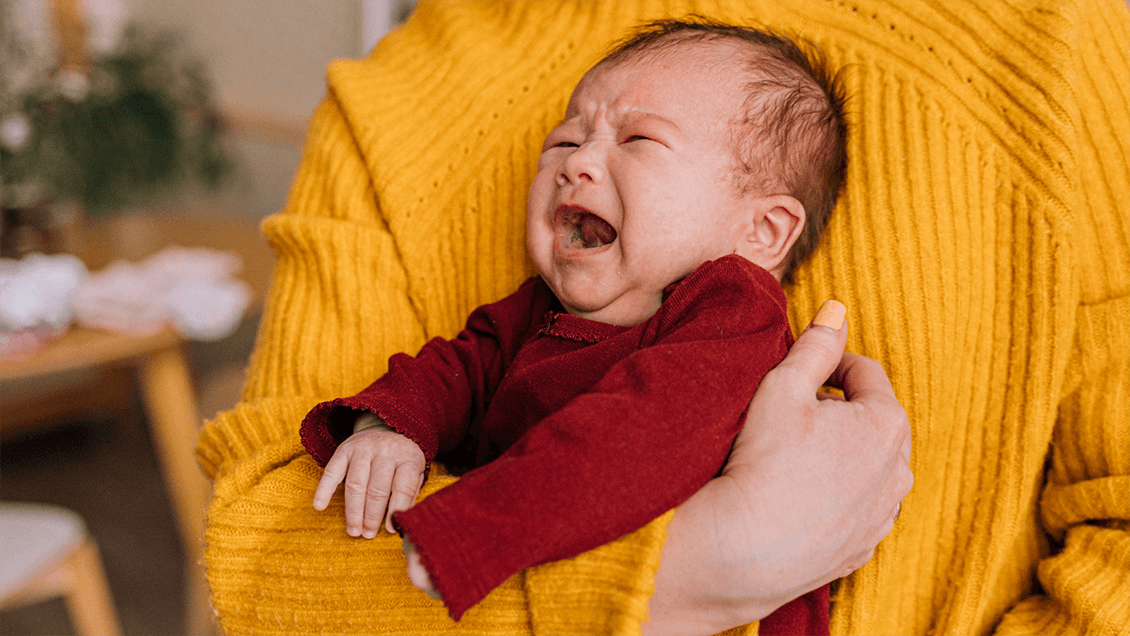 A baby being comforted by a parent, representing ways to soothe a fussy baby anytime, anywhere.