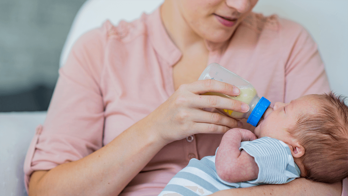 A newborn baby breastfeeding, representing cluster feeding and early infant feeding patterns.