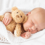 Baby sleeping peacefully, relevant to tips for extending newborn sleep.