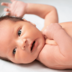 Close-up of a newborn baby with open eyes looking upwards, relevant to understanding baby eyesight.